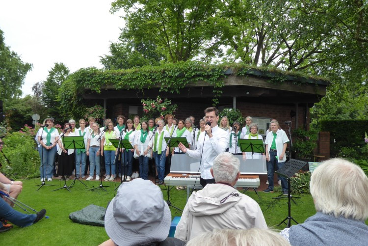 Chorleiter Simon Wiesrecker begrüßt das Publikum und stimmt auf das nächste Lied ein.